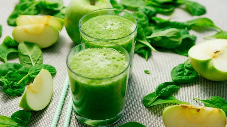 Two glasses of green smoothie with fresh spinach and green apples