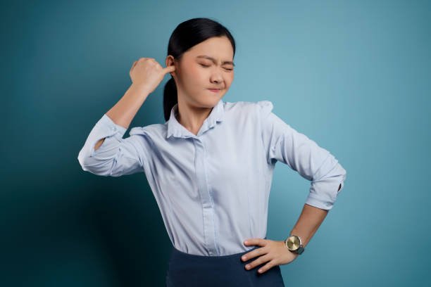 Woman holding her ear in discomfort from a blocked ear