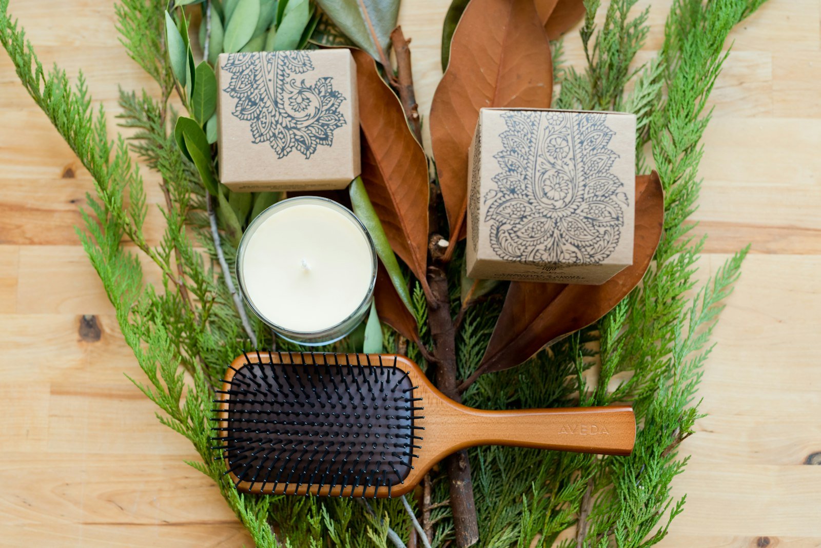 Homemade natural shampoo: wooden hair brush, handmade soap and fresh greenery on a wooden table